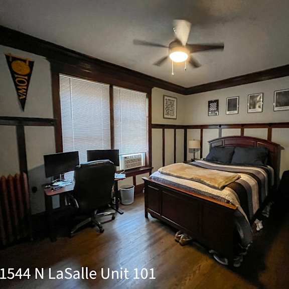 a bedroom with a bed, desk, and chair.