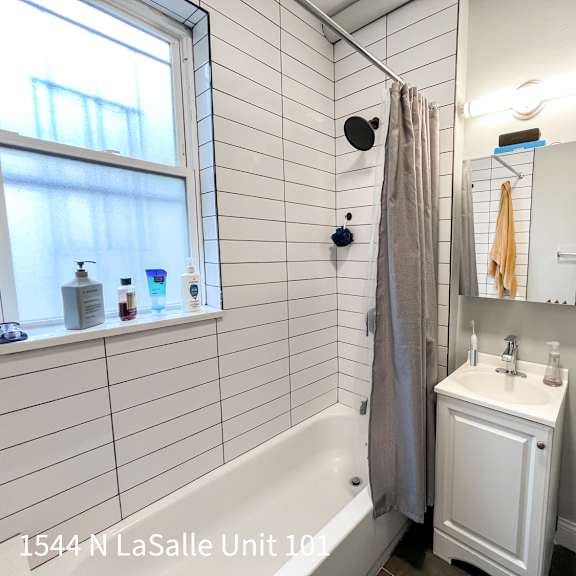a white bathroom with a tub, toilet, and sink.