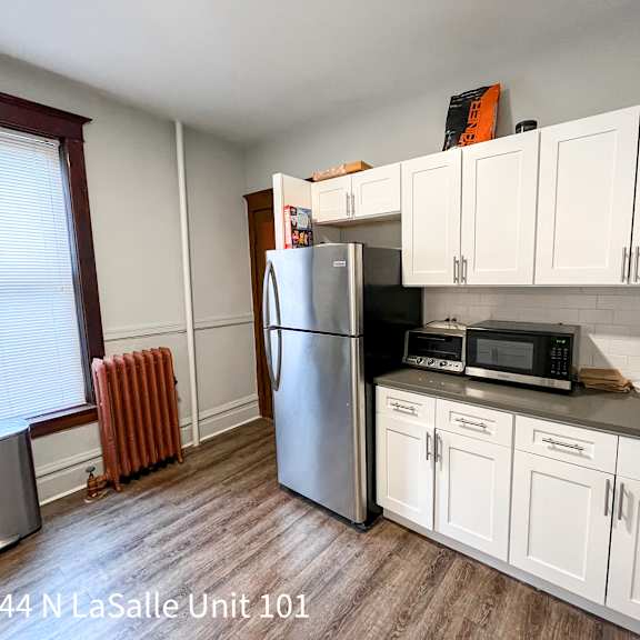 a kitchen with white cabinets and a stainless steel refrigerator.