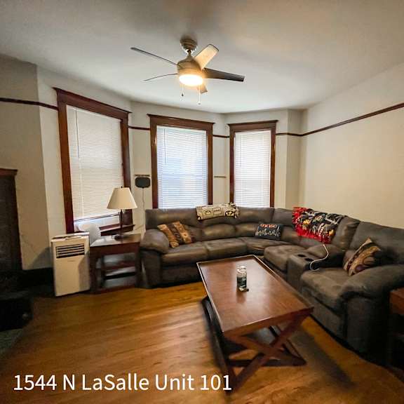 a living room with a couch, a coffee table, and a ceiling fan.