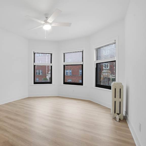 a room with a wooden floor and a white ceiling fan.