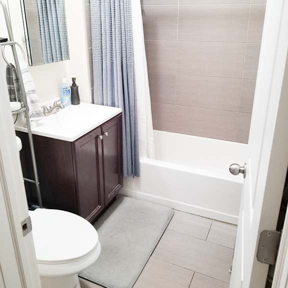 a white toilet is in a bathroom with a white sink and a white door.