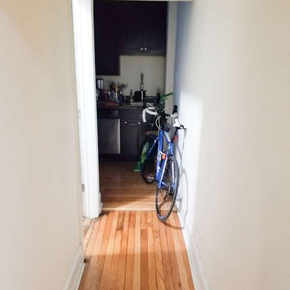 a bicycle is leaning against the wall in a narrow hallway.