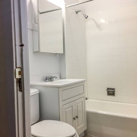 a white bathroom with a toilet, sink, and bathtub.