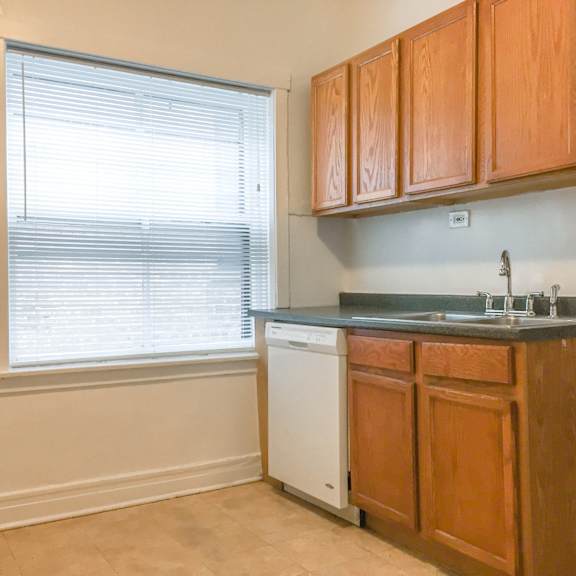 a kitchen with wooden cabinets and a white dishwasher.