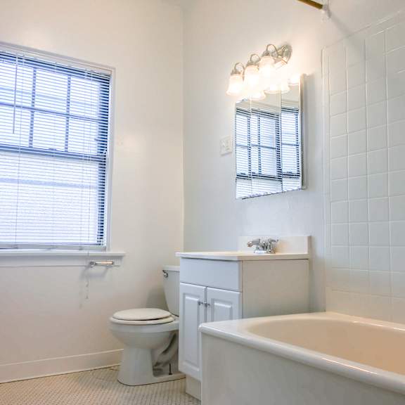 a white bathroom with a toilet, sink, and tub.