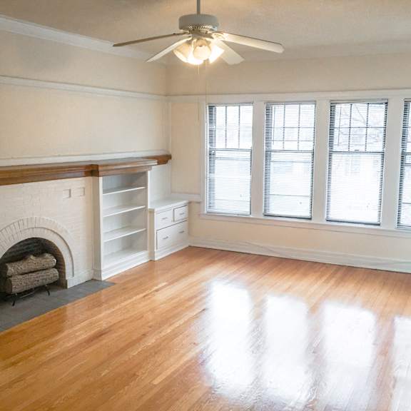 a room with a fireplace and a ceiling fan.
