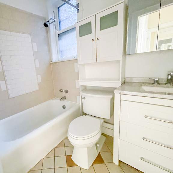 a white bathroom with a tub, toilet, and sink.