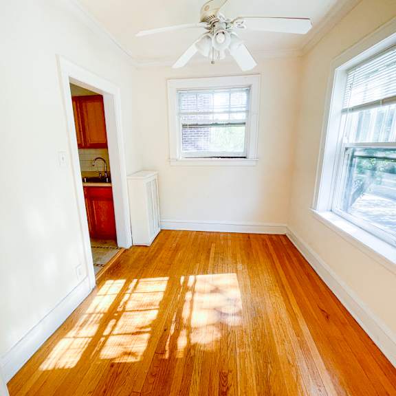 a room with a ceiling fan and wooden floors.