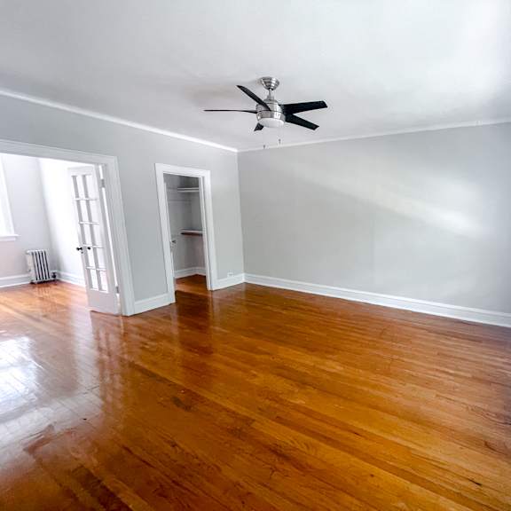 a room with wooden floors and a ceiling fan.
