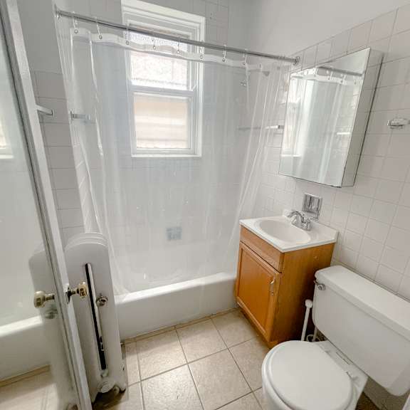 a white bathroom with a toilet, sink, and bathtub.