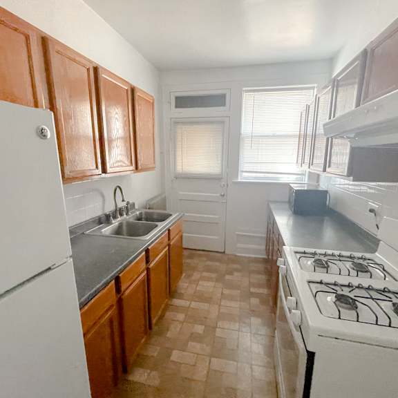 a kitchen with white appliances and brown cabinets.