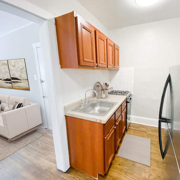 a kitchen with wooden cabinets and a stainless steel refrigerator.