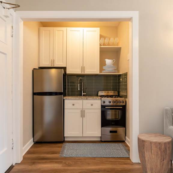a small kitchen with stainless steel appliances and white cabinets
