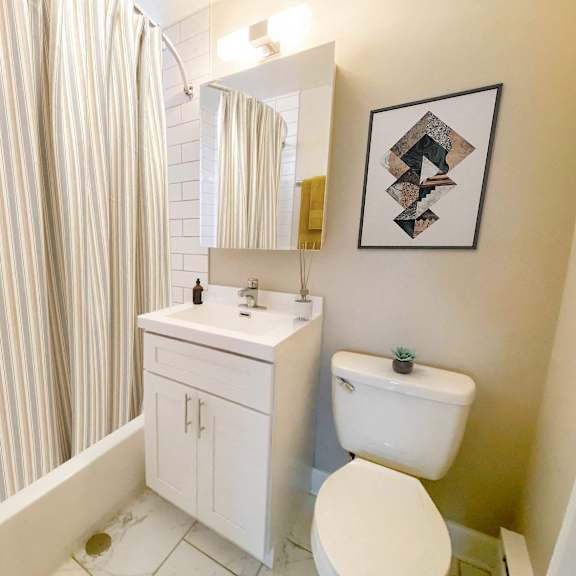 a bathroom with a toilet and a sink and a shower