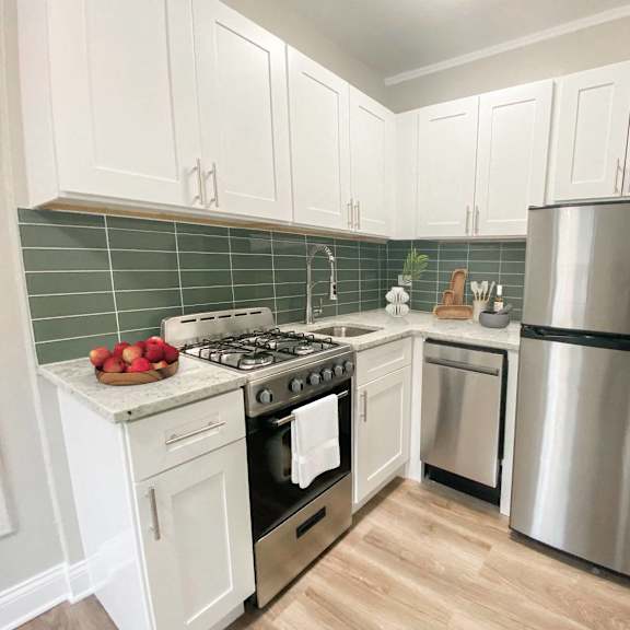 a kitchen with a stove, refrigerator, and cabinets.