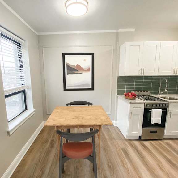 a kitchen with a table and chairs in the middle of the room.
