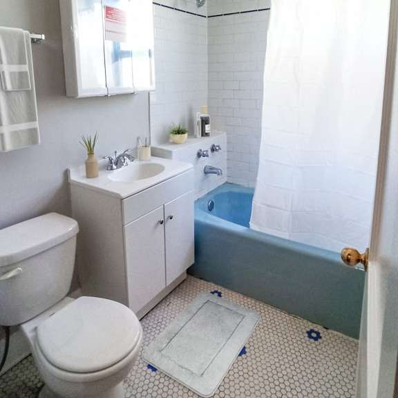 a white toilet sits in a bathroom with a blue and white tiled floor.