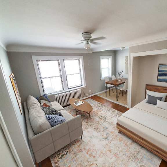 a bedroom with a bed, couch, and rug.
