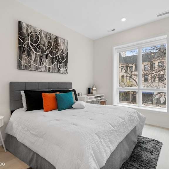 a bedroom with a bed and a large window