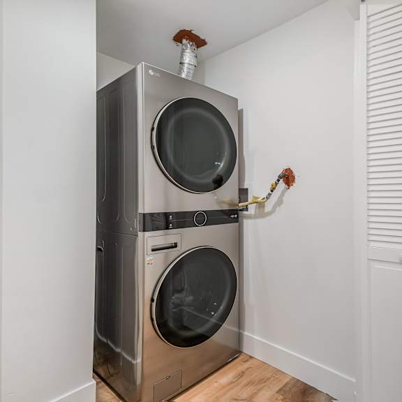 a modern laundry room with a washer and dryer built into the wall.