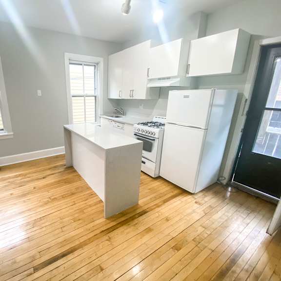 a kitchen with wooden floors and white appliances.