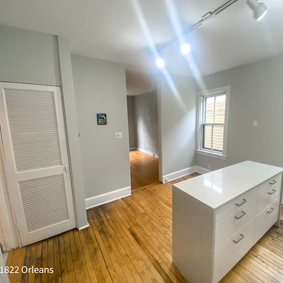 a room with a white desk and wooden floors.