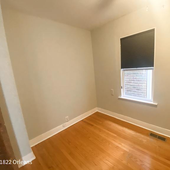 a room with a window and wooden flooring.