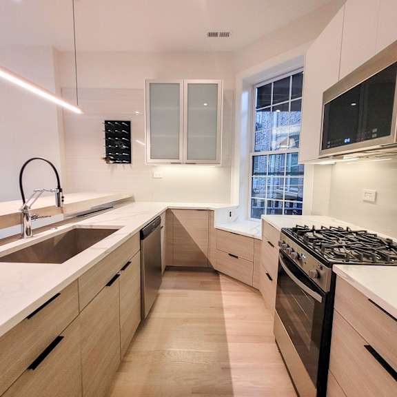 a modern kitchen with wooden cabinets and a stainless steel stove.