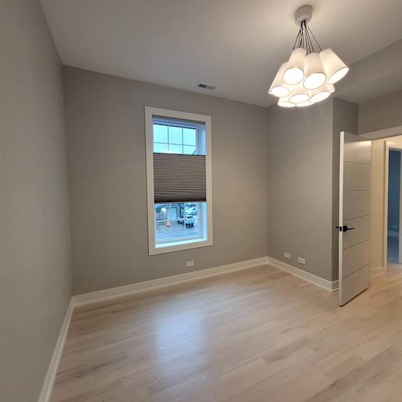 a room with a large window and a wooden floor.