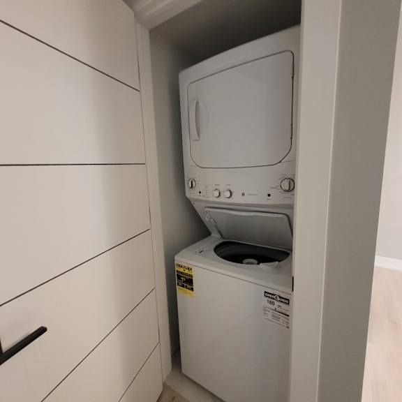 a white dryer is in a cabinet.