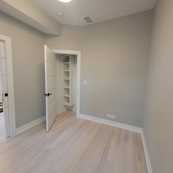 a room with a white door and a white shelving unit.