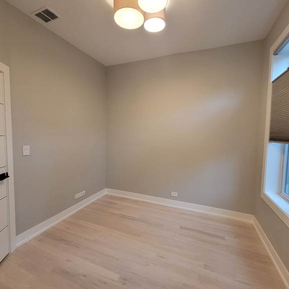 a room with light grey walls and wooden flooring.
