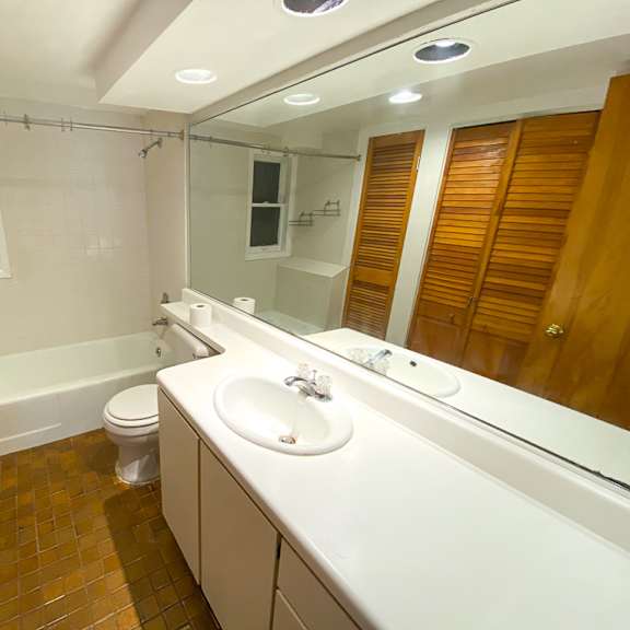 a bathroom with a white sink, toilet, and bathtub.