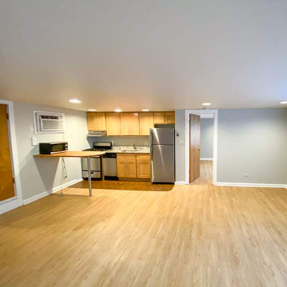 a kitchen with wooden floors and a refrigerator.