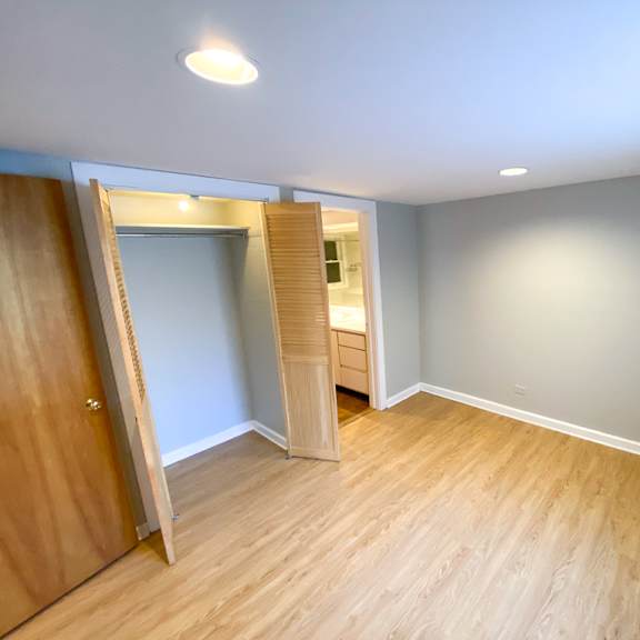 a room with wooden floors and a door leading to another room.
