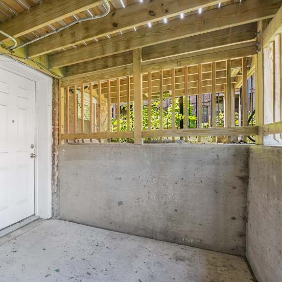 a room under construction with a white door and wooden beams.