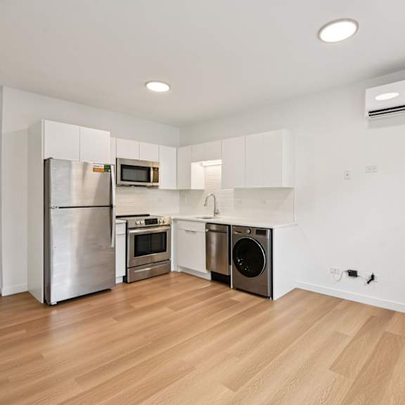 a kitchen with wooden floors and stainless steel appliances.
