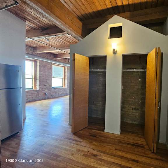 an empty living room with a vaulted ceiling and a walk in shower