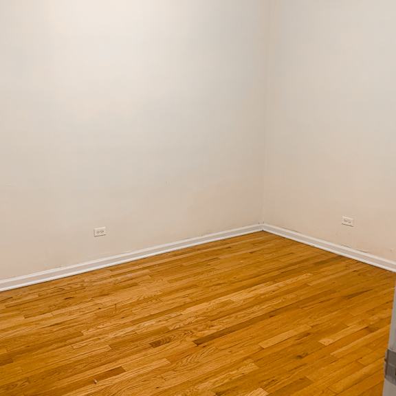 a room with wooden flooring and a white door.