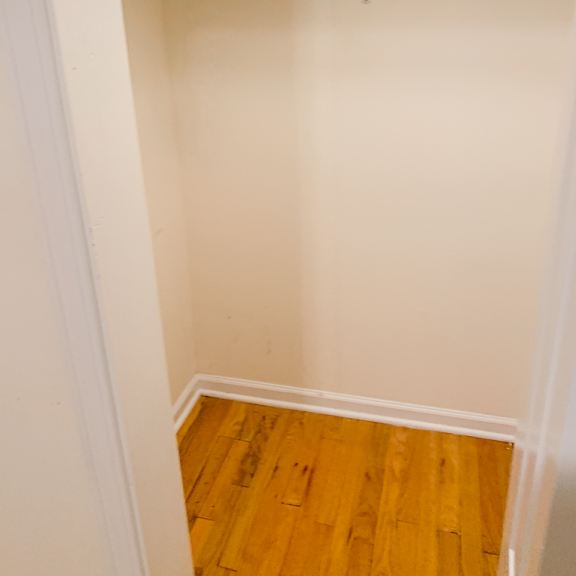 a white closet with a wooden floor.
