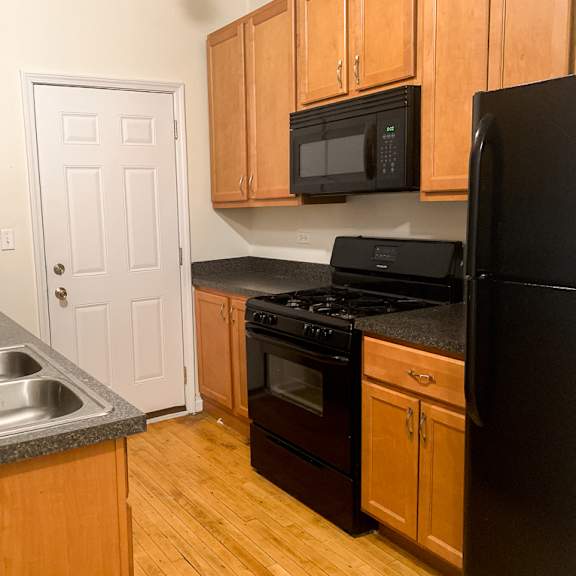 a kitchen with wooden cabinets and black appliances.