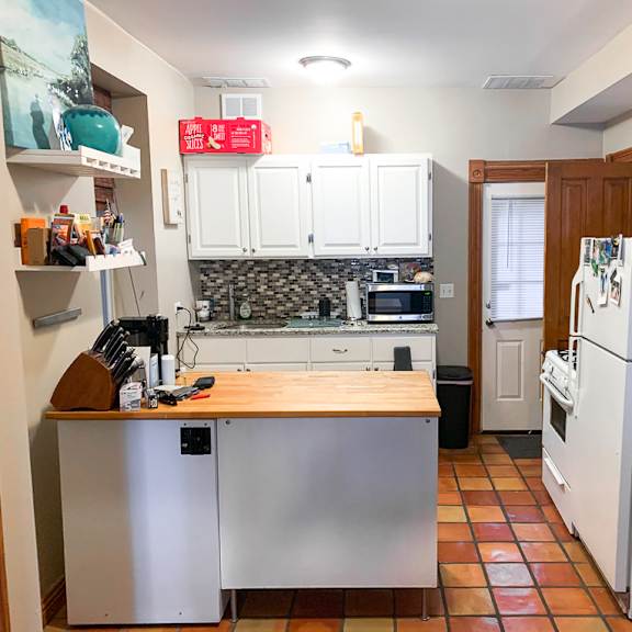 a kitchen with a refrigerator, oven, and sink.