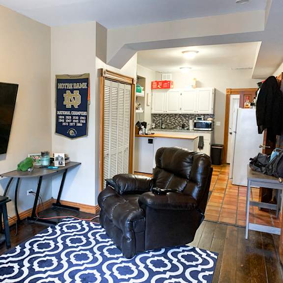 a living room with a black leather chair and a tv.
