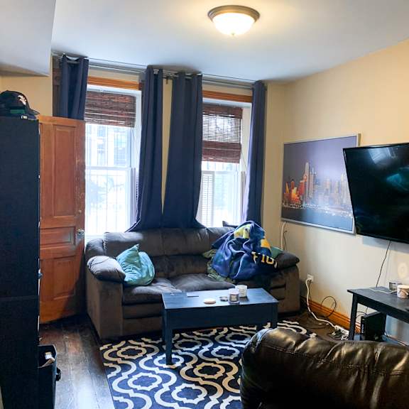 a living room with a couch, a chair, and a television.