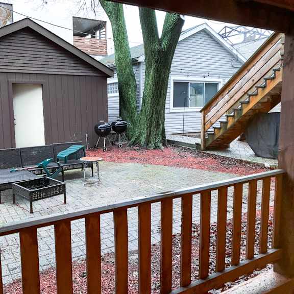 a backyard with a wooden deck and a tree.