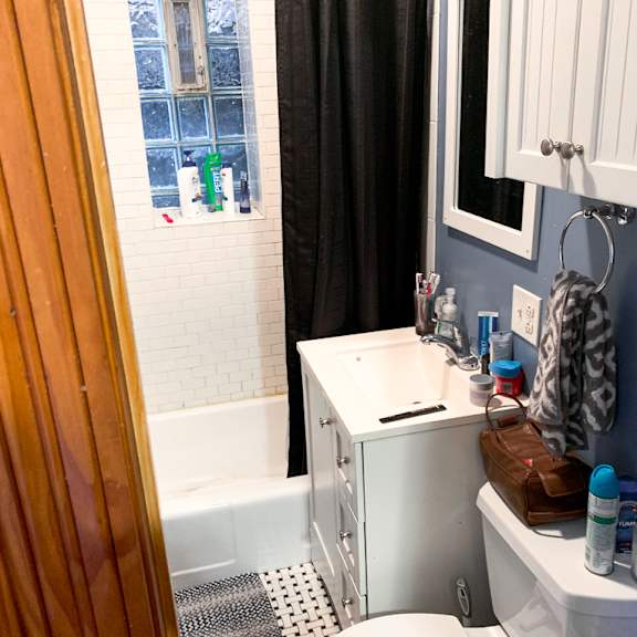 a bathroom with a toilet, sink, and shower.