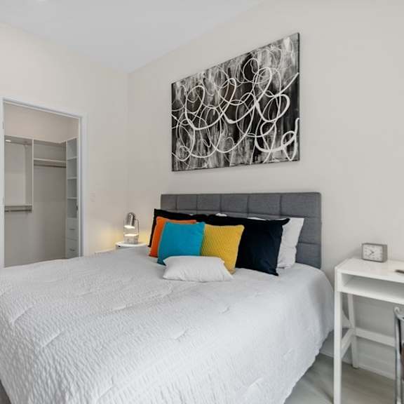 a white bedroom with a large bed and a bathroom