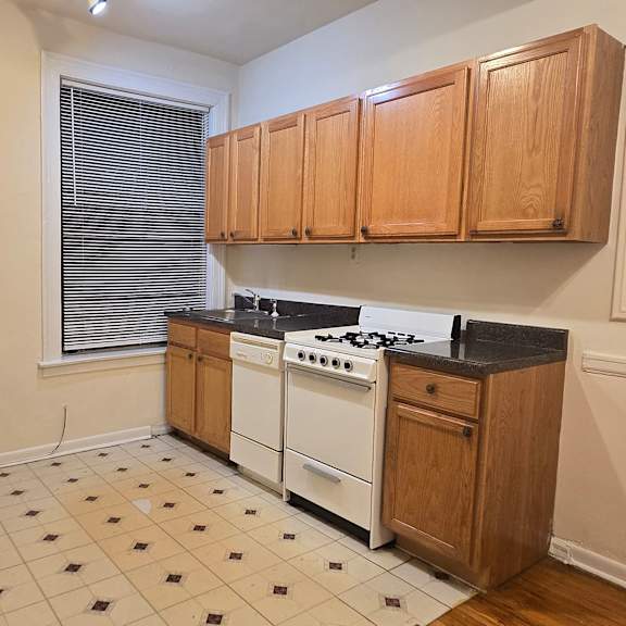 a kitchen with white appliances and wooden cabinets.