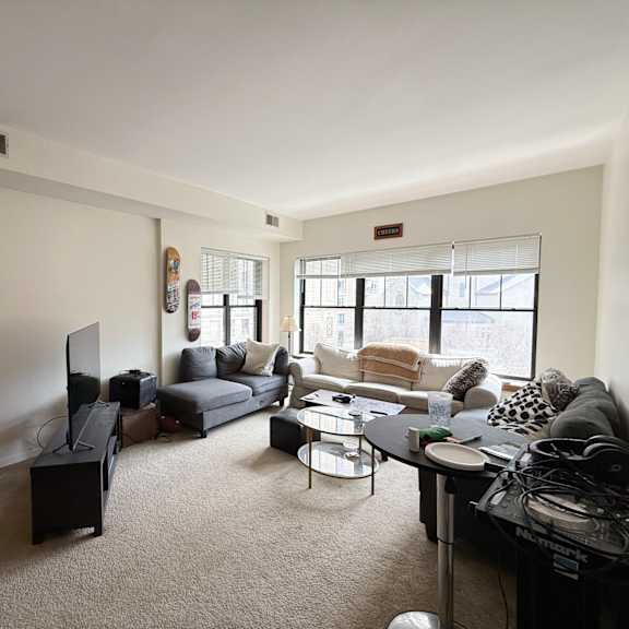 a living room with a grey couch, a black coffee table, and a flat screen tv.